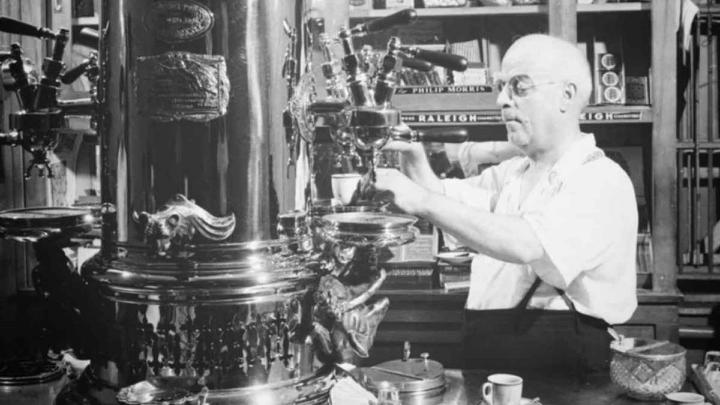 An image showcasing a man using an espresso coffee machine invented by Luigi Bezzera to brew espresso coffee in the early invention of espresso machine