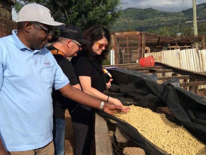 Lameck, co-founder of Solai Coffee, discussing coffee wits with Bob and Michelle from OBIIS The Solai Coffee team is observing dry green bean coffee with OBIIS founders.