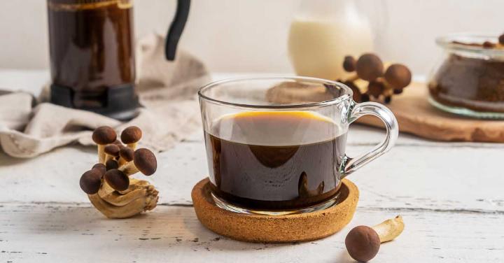 A cup of coffee brew with mushrooms on the concrete surface. Ingredients for making mushroom coffee.