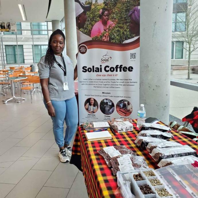 Symposium in Huston Solai Coffee attendee stands beside an impressive display of their signature products at the Color of Coffee Symposium in Huston.