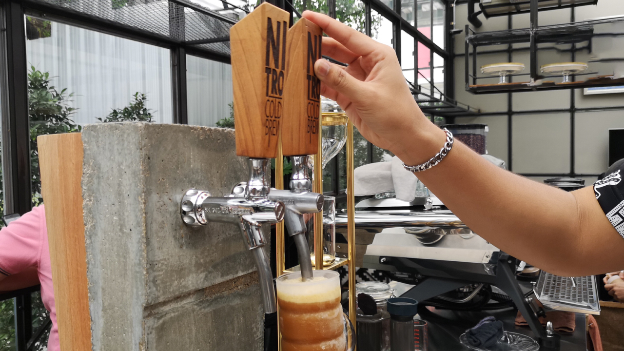 An image of a Nitro Cold Brew tap pouring the beverage into a glass showcases its visually appealing cascading effect as tiny nitrogen bubbles infuse the coffee, creating a smooth and creamy texture.
