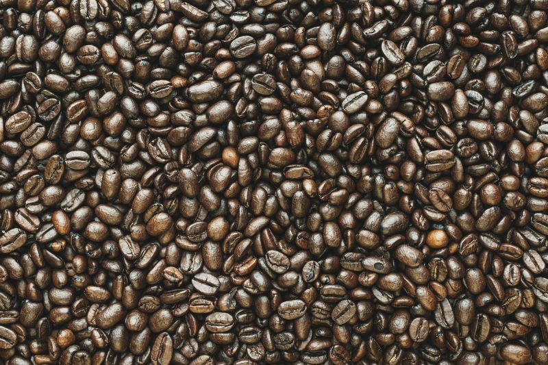 French roast coffee beans with a nearly black color and shiny surface, reflecting their robust and intense flavor profile.
