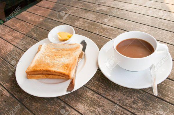 An image of bread toast with butter and a cup of freshly brewed coffee for tasting