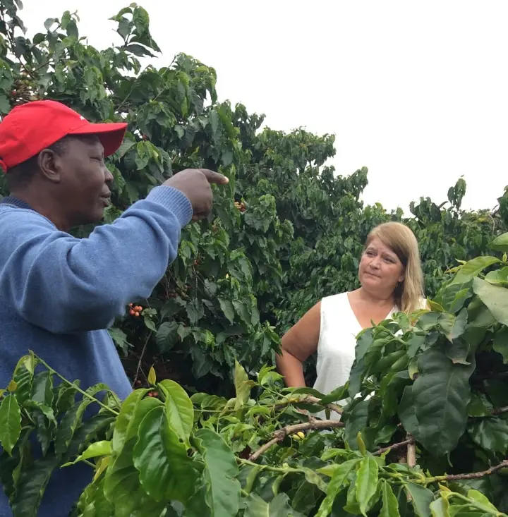 A coffee farmer engaged in a deep discussion about sustainable coffee farming and production, focusing on practices that support the environment and the community.