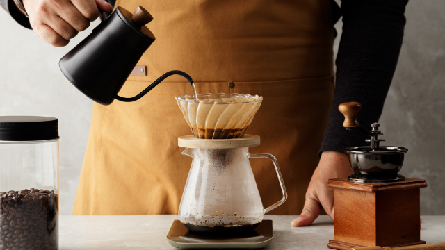 A Person engaged in a relaxing coffee ritual, using a slow, deliberate pour-over method for a mindful morning coffee routine.