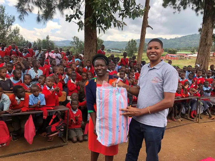 Members of the Solai Coffee team handing out gifts to students and teachers, with smiles and expressions of gratitude shared among the crowd. Activity 1