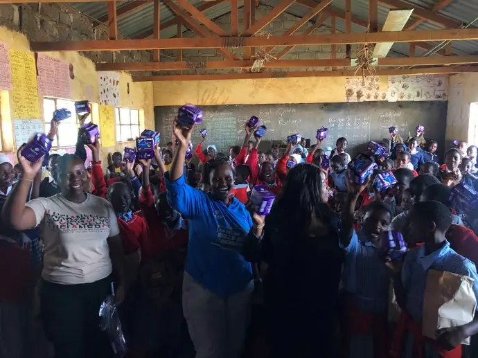 Students joyfully cheering and clapping after receiving gifts from the Solai Coffee team, celebrating the special moment. Activity 1