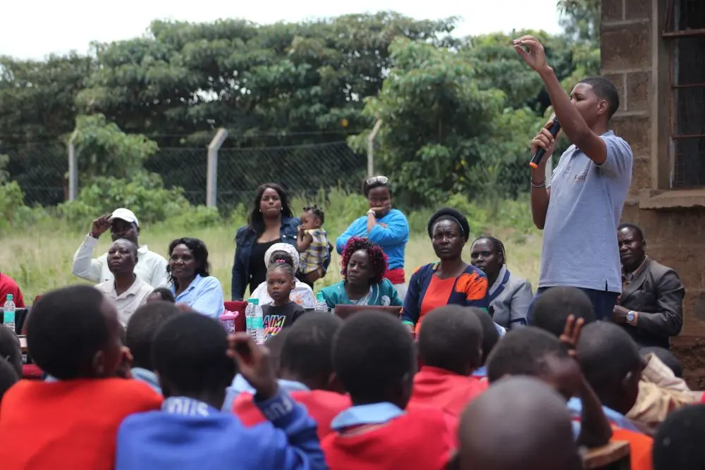 Peter from the Solai Coffee team addressing the students, teachers, and guests, speaking passionately to the attentive crowd. Activity 2