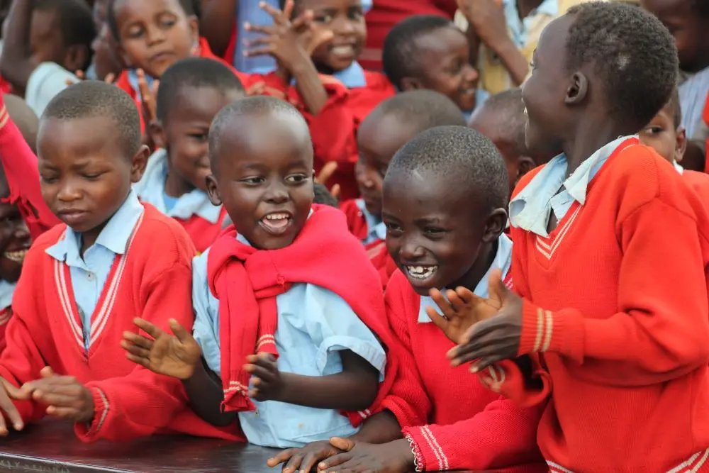 Students joyfully cheering and clapping after receiving gifts from the Solai Coffee team, celebrating the special moment. Activity 4