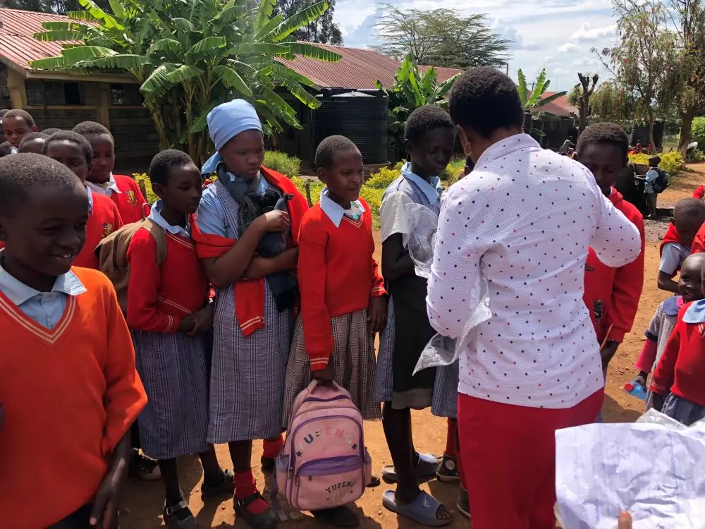 Members of the Solai Coffee team handing out gifts to students and teachers, with smiles and expressions of gratitude shared among the crowd. Activity 6