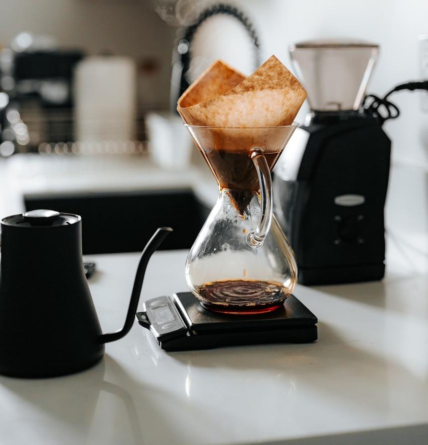 A home setup of coffee brewing tools like  drip coffee maker and  a gooseneck kettle