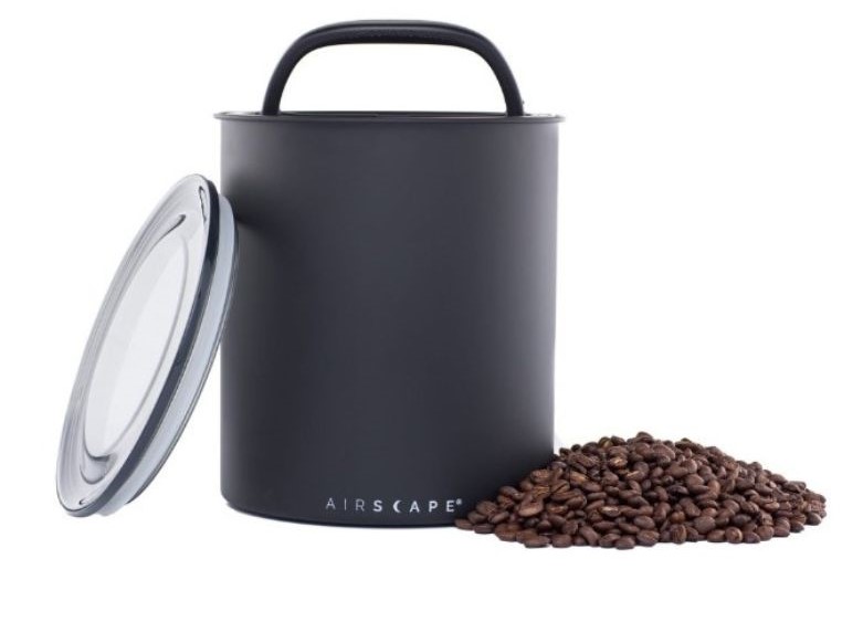 A sleek Solai Coffee canister beside freshly roasted coffee beans, highlighting proper storage methods for maintaining freshness.