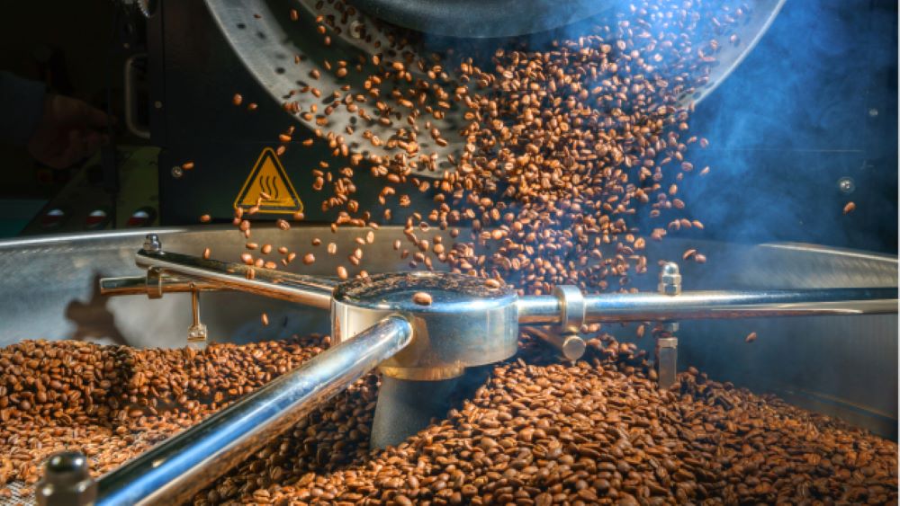 Coffee beans in the roasting process, emphasizing the importance of resting them for 3-7 days to degas for the best flavor.
