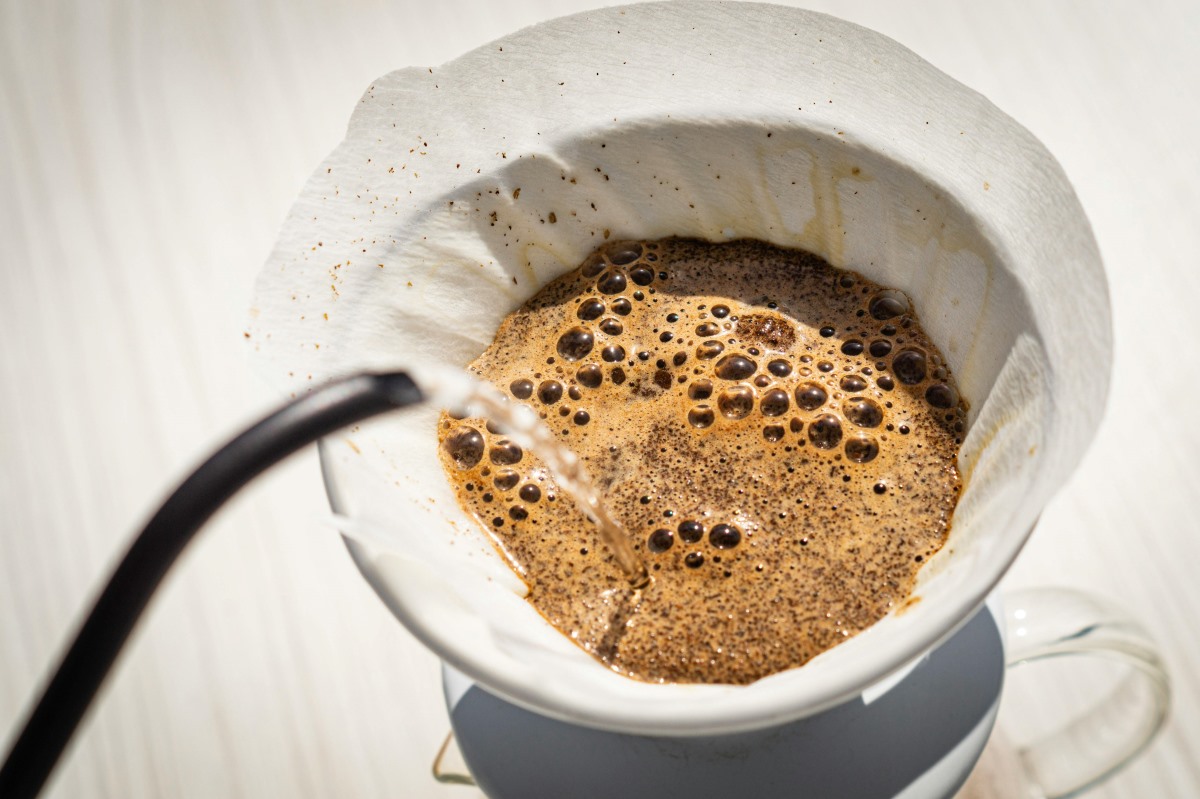 Coffee blooming in a portafilter, with visible bubbles forming as hot water releases the freshness of the grounds.