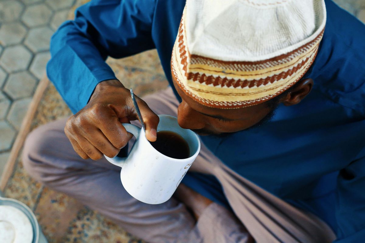 An African man tasting his freshly brewed coffee, his joyful expression reflecting the diverse flavors in the cup.