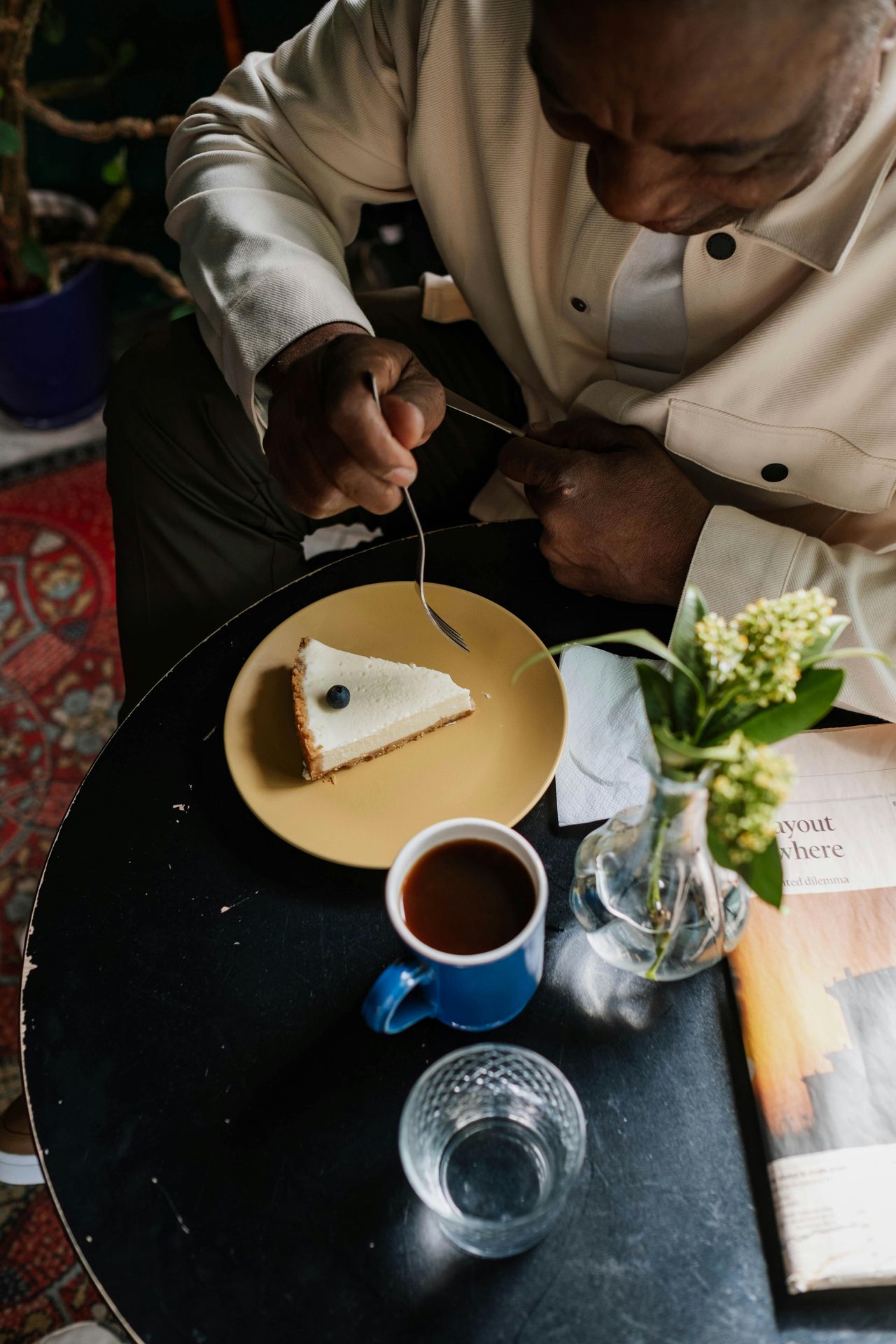 An elderly man savoring a cheese and coffee pairing, thoughtfully tasting a bite of cheese followed by a sip of coffee, showcasing a traditional and cultural experience.