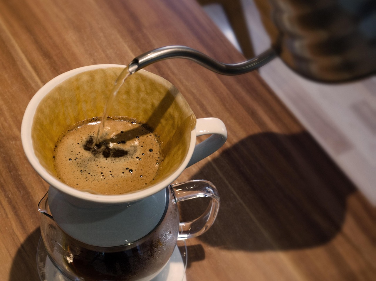 Pouring hot water over coffee grounds using a pour-over method, emphasizing the importance of water temperature in extraction.