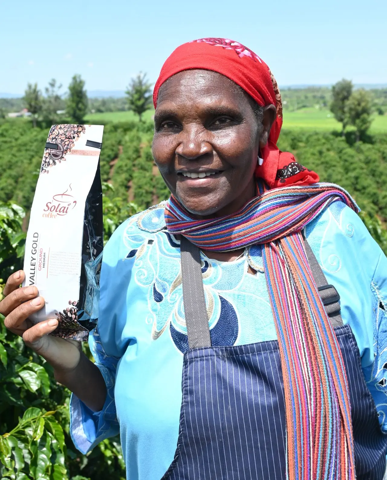 Women in coffee farming Female coffee farm owner proudly holding a Solai Coffee bag, highlighting women in coffee leadership farming.