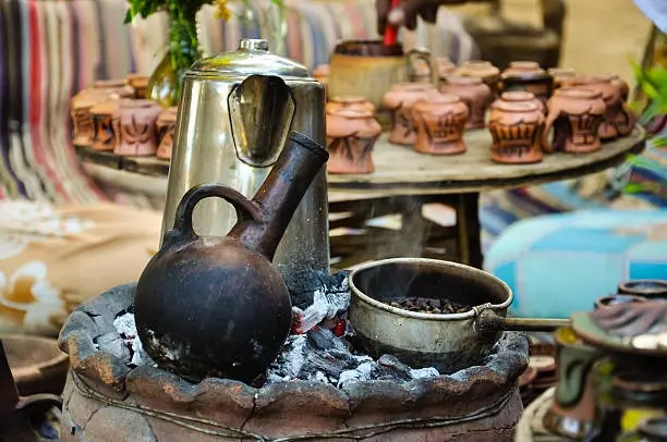 An Ethiopian coffee ceremony scene with traditional clay cups and roasting 