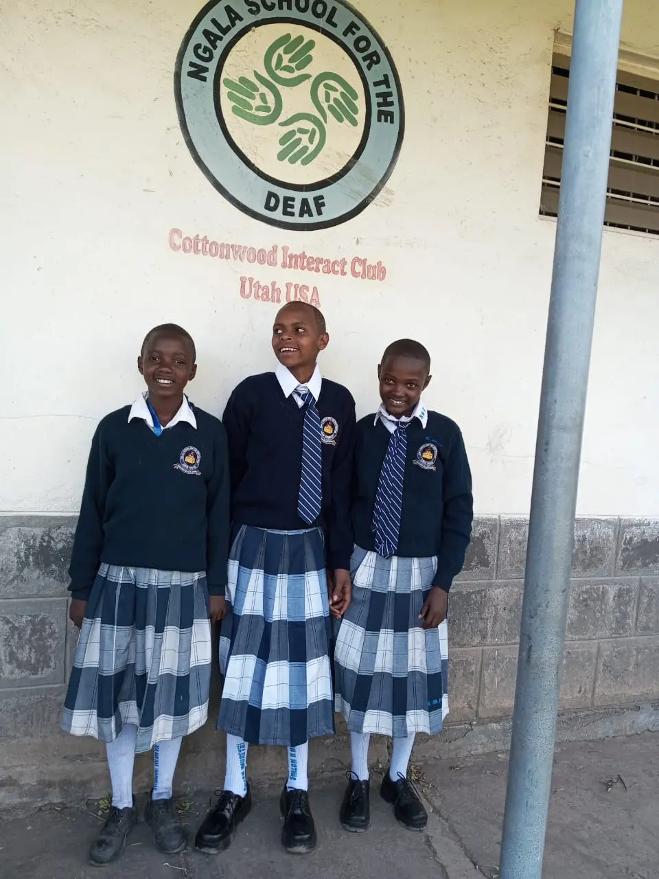 Sharom Njoki, a bright student sponsored by Solai Coffee, stands with her classmates at Ngara School for the Deaf. She is now part of an inclusive learning environment that supports her communication and academic growth.