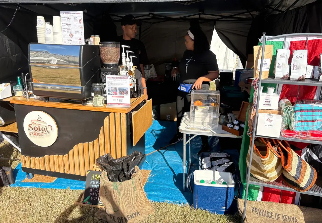 Specialty coffee in mature consumer markets Solai Coffee pop-up stand with espresso machine, baristas, and packaged Kenyan coffee at an outdoor market, showing direct-to-consumer retail.