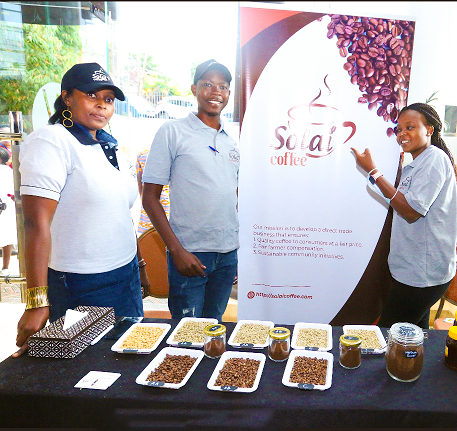 Solai Coffee team stands beside an impressive display of their signature products at the bustling Coffee Festival in Nairobi.
